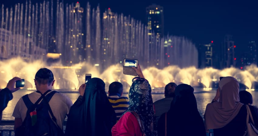 A group of visitors film the Bellagio Fountain nighttime water show on their smart phones