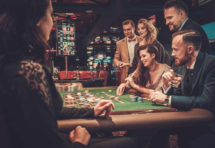 friends around a casino table game placing their bets