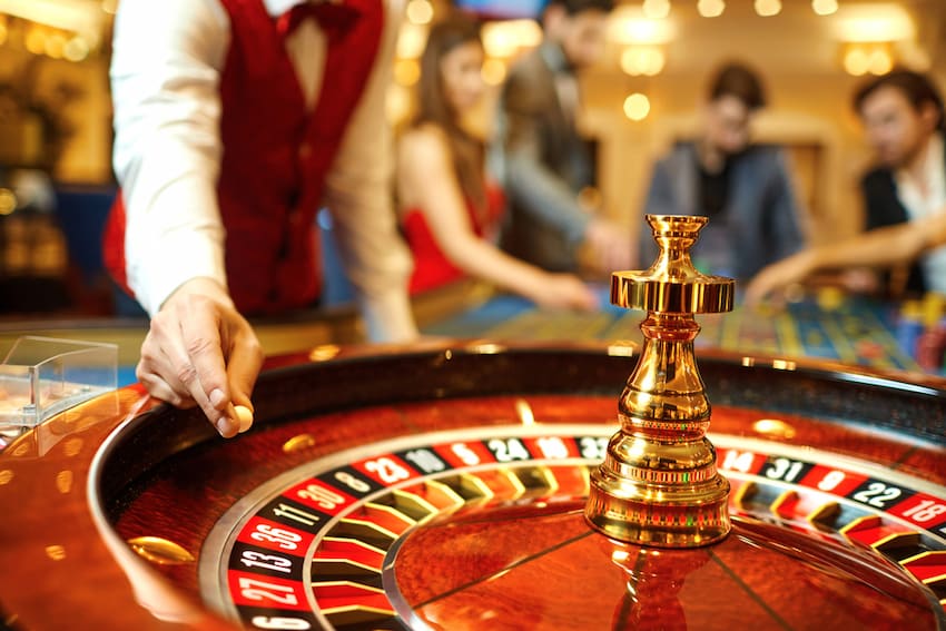 a casino employee gets ready to drop a roulette ball