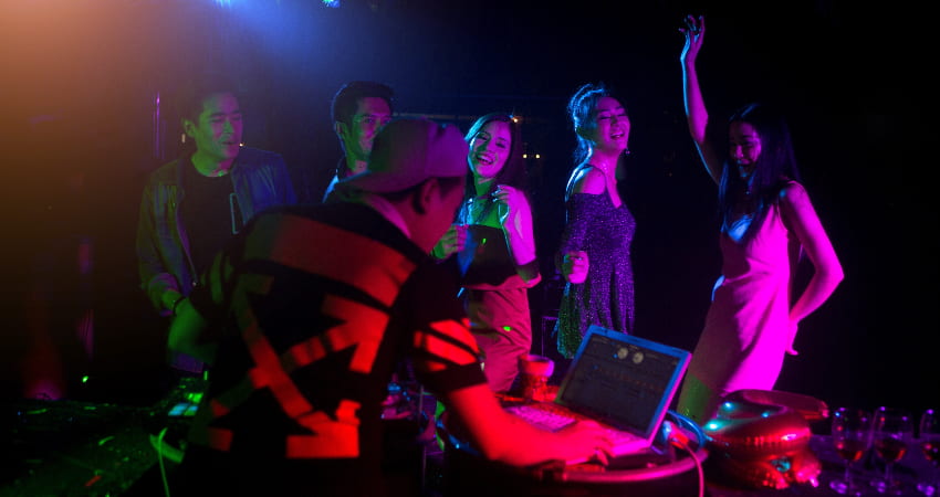 Dancers lit by rainbow light dance in a night club