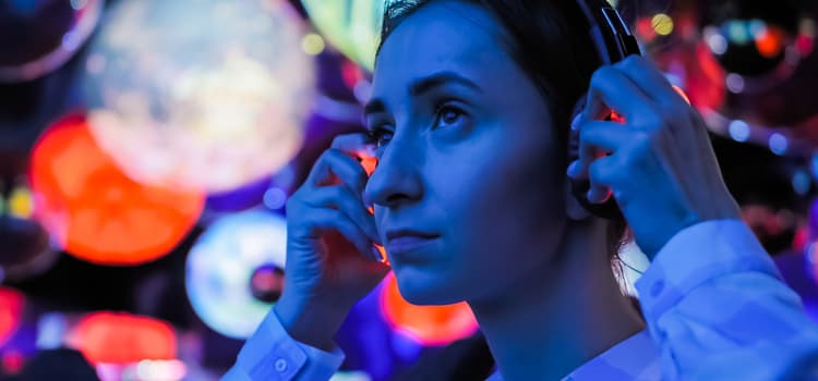 a woman puts on headphones with neon lights shining around her