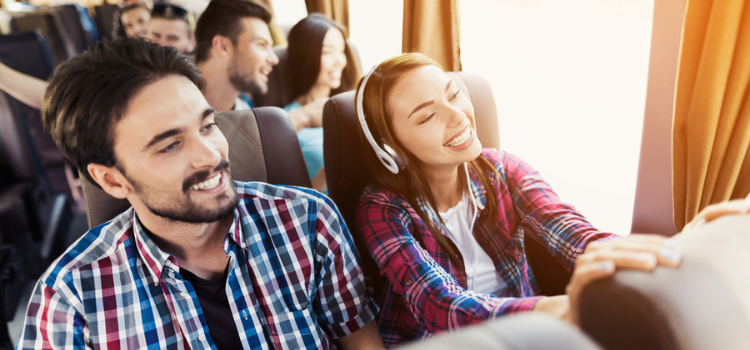 a man and woman relaxing in the seats of a charter bus